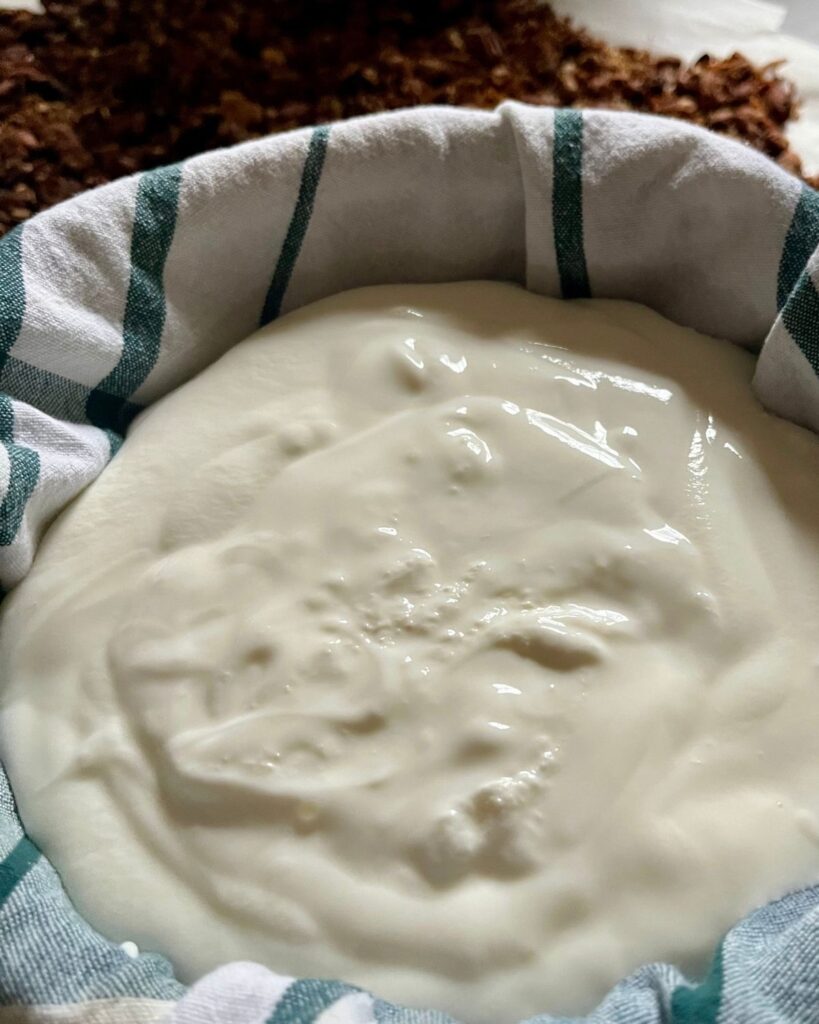 homemade yogurt in a cloth-covered strainer