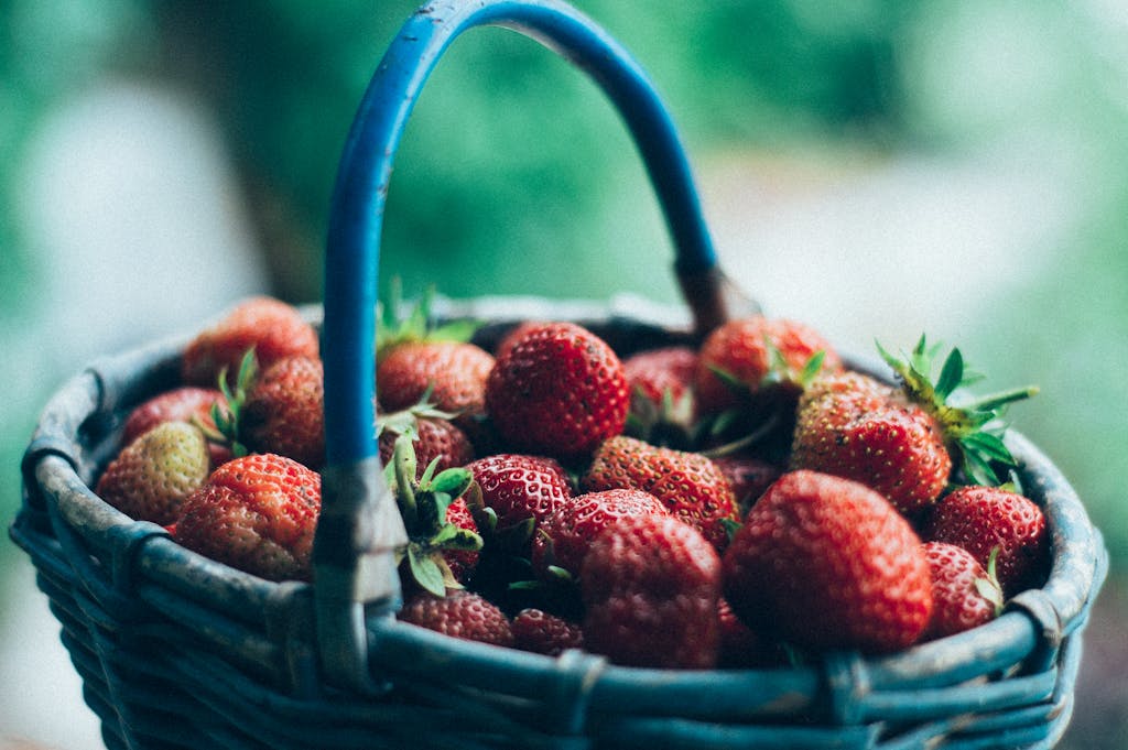 Vivid close-up of fresh, juicy strawberries overflowing in a wicker basket.