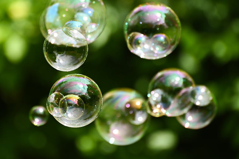 Vibrant soap bubbles floating in a sunlit garden create a playful and dreamy atmosphere.