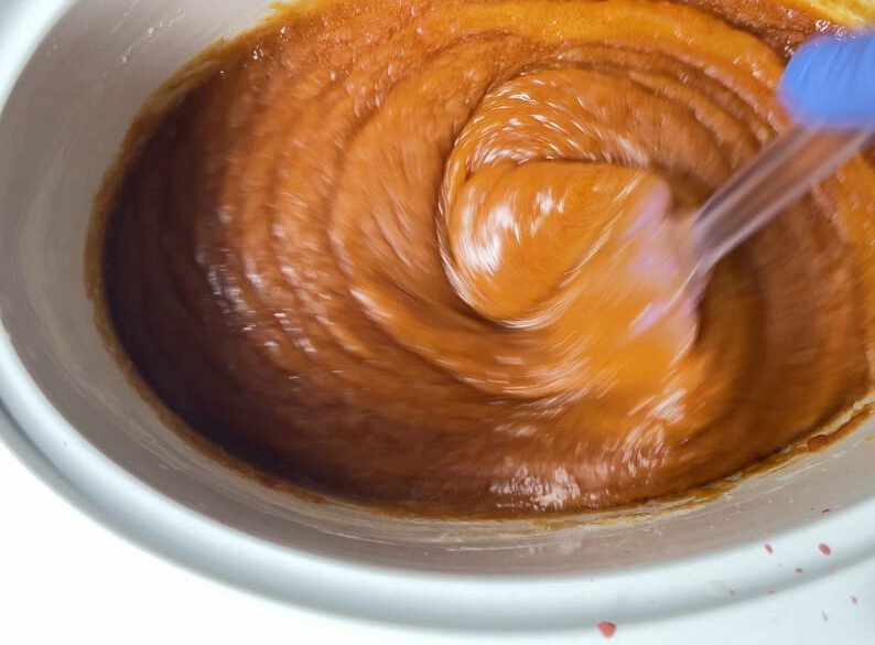 Stirring hot process soap in a crock pot