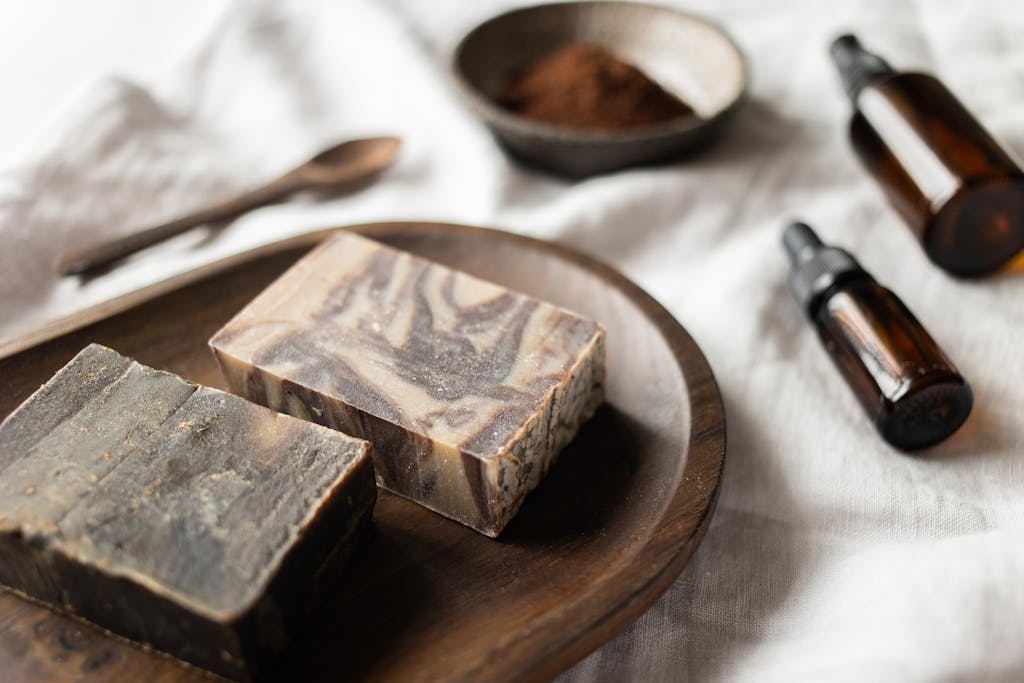 A stylish and natural flat lay of handmade soap, essential oils, and coffee ingredients.